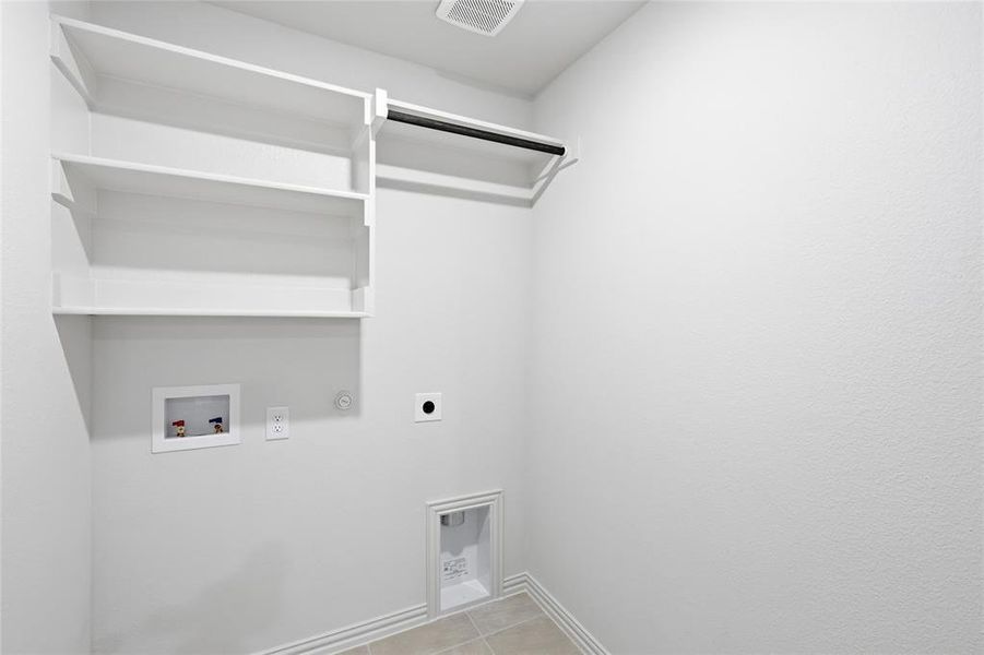 Laundry room featuring gas dryer hookup, hookup for an electric dryer, light tile patterned flooring, and washer hookup