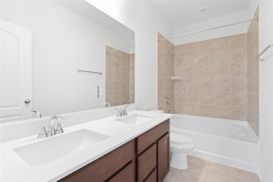 This primary bathroom features an oversized tub/shower combination with tile surround, stained cabinets with light countertops and dual vanities, high ceilings, custom paint, sleek and dark modern finishes.