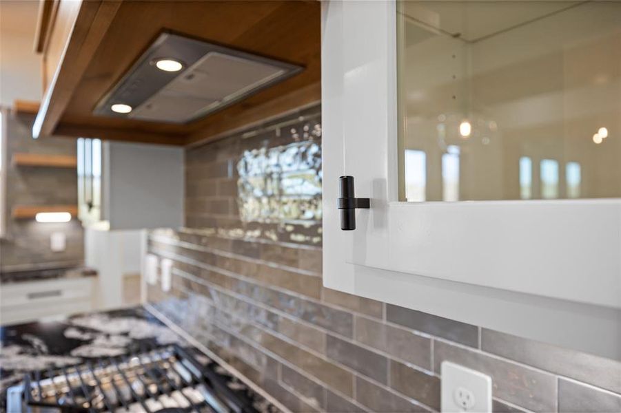 Kitchen featuring white cabinets and tasteful backsplash