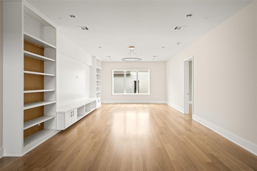 Upstairs game room with clean lines, custom built-ins, and a designer light fixture adding a refined focal point.