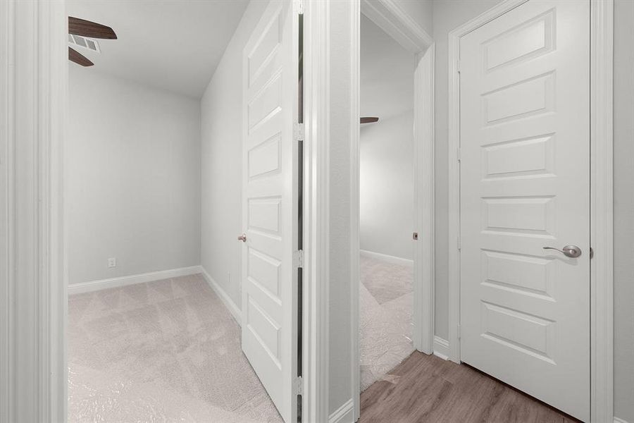 Hall featuring a view into both secondary bedrooms.