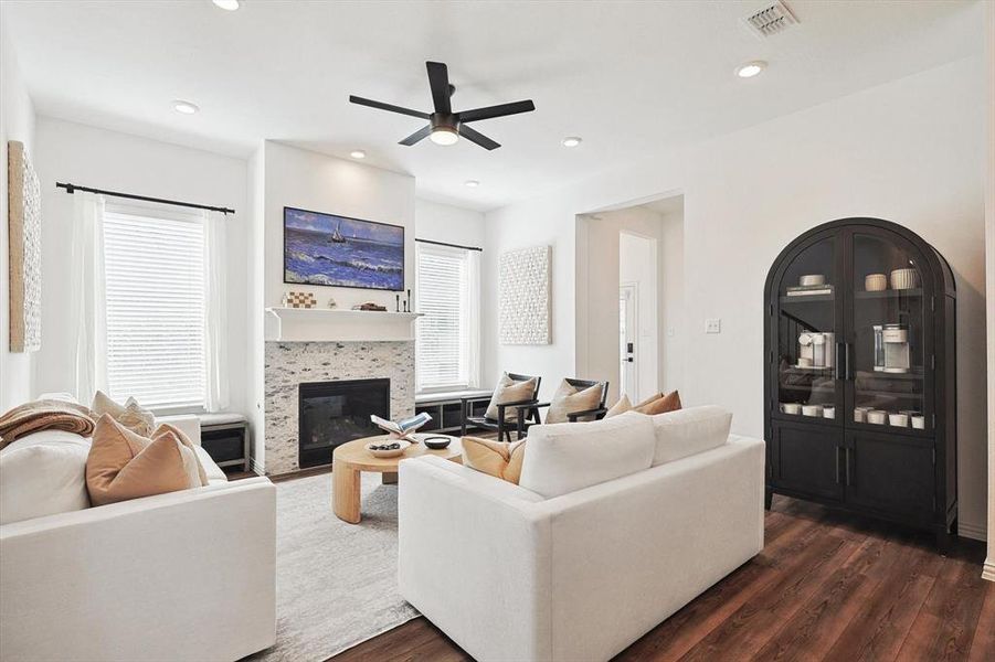 Living room with dark hardwood / wood-style floors, a tile fireplace, and ceiling fan