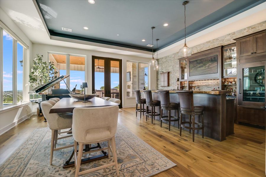 Dining room featuring a tray ceiling, light wood finished floors, and recessed lighting Dining room featuring a tray ceiling, light wood finished floors, and recessed lighting