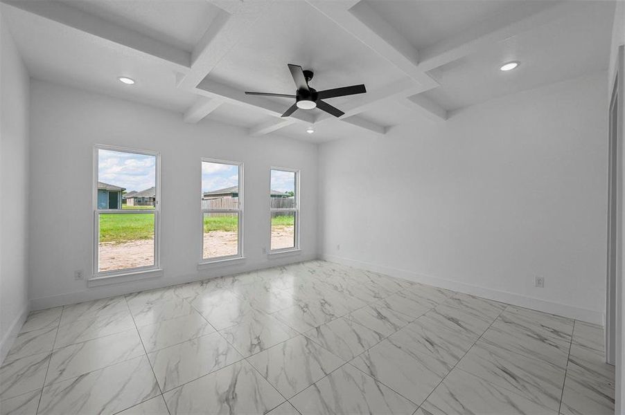 Tiled spare room featuring ceiling fan, beam ceiling, and coffered ceiling