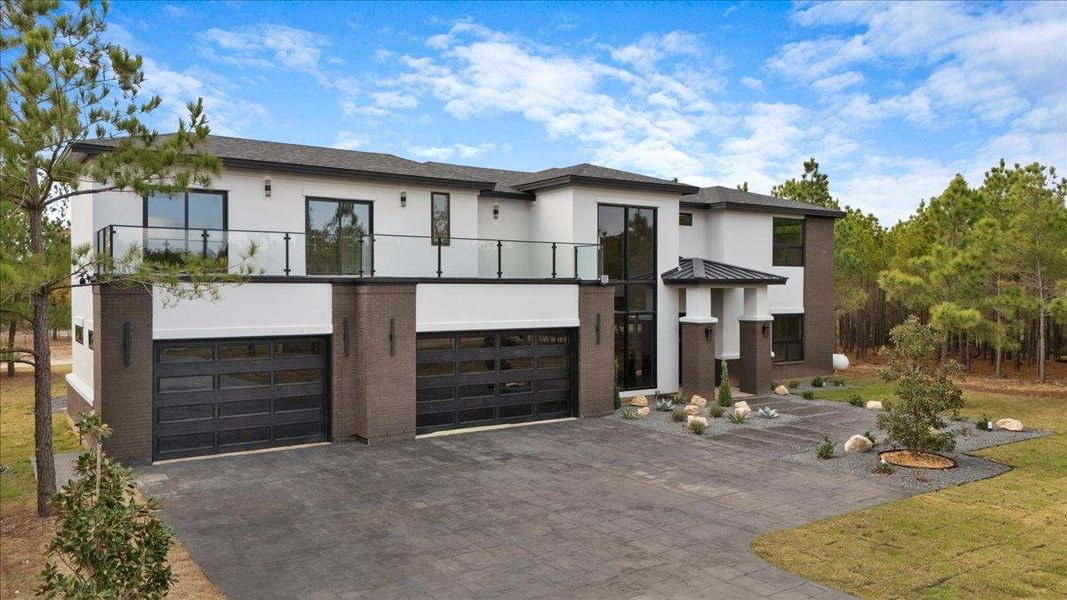 Contemporary Luxury house featuring stucco siding, stamped concrete driveway, and sprawling balcony. Contemporary Luxury house featuring stucco siding, stamped concrete driveway, and sprawling balcony.