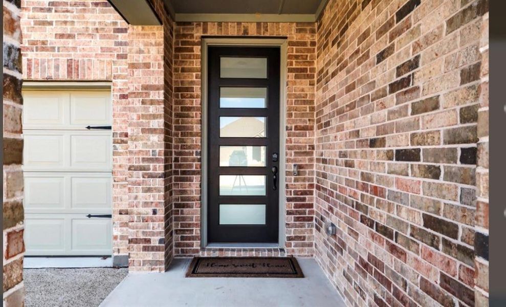 View of exterior entry with brick siding
