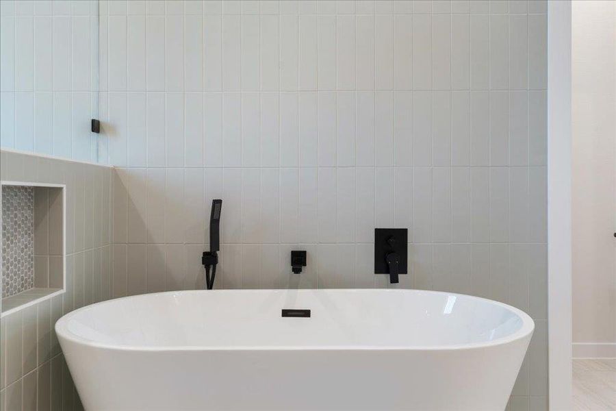 Bathroom with a soaking tub and tile walls