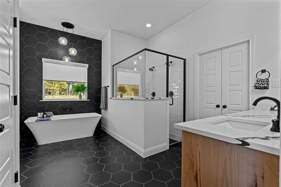 Bathroom with tile patterned floors, vanity, tile walls, and plus walk in shower