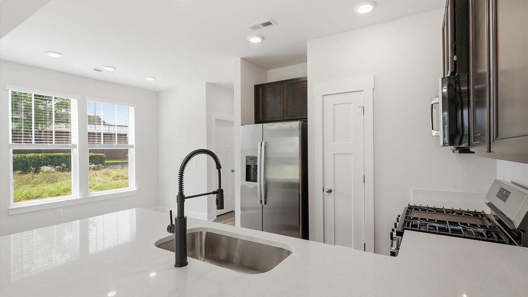 Exclusive DRB Homes kitchen with quartz countertops and elevated finishes in a prime location
