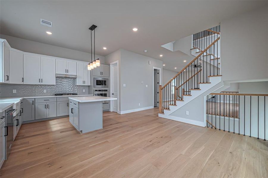 Discover this sleek, modern three-story home with a striking white facade, expansive windows for abundant natural light, and a stylish black garage door. A chic balcony above the entrance enhances its contemporary appeal.