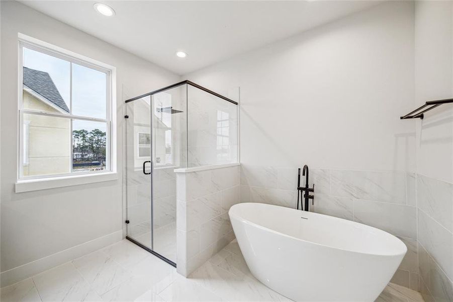 Luxurious primary bathroom featuring modern fixtures and premium finishes, offering a serene retreat for relaxation.