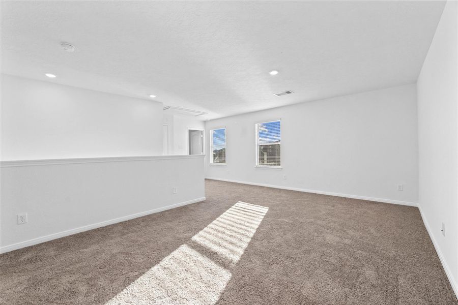 Head upstairs and enjoy a day of fun and relaxation in this fabulous game room! This inviting space features plush carpeting, high ceilings, recessed lighting, custom paint, and windows with privacy blinds. Head upstairs and enjoy a day of fun and relaxation in this fabulous game room! This inviting space features plush carpeting, high ceilings, recessed lighting, custom paint, and windows with privacy blinds.