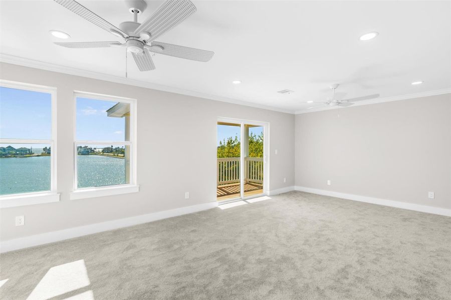 Primary bedroom on the second floor featuring two ceiling fans, crown molding, fresh carpet and your own private deck Primary bedroom on the second floor featuring two ceiling fans, crown molding, fresh carpet and your own private deck