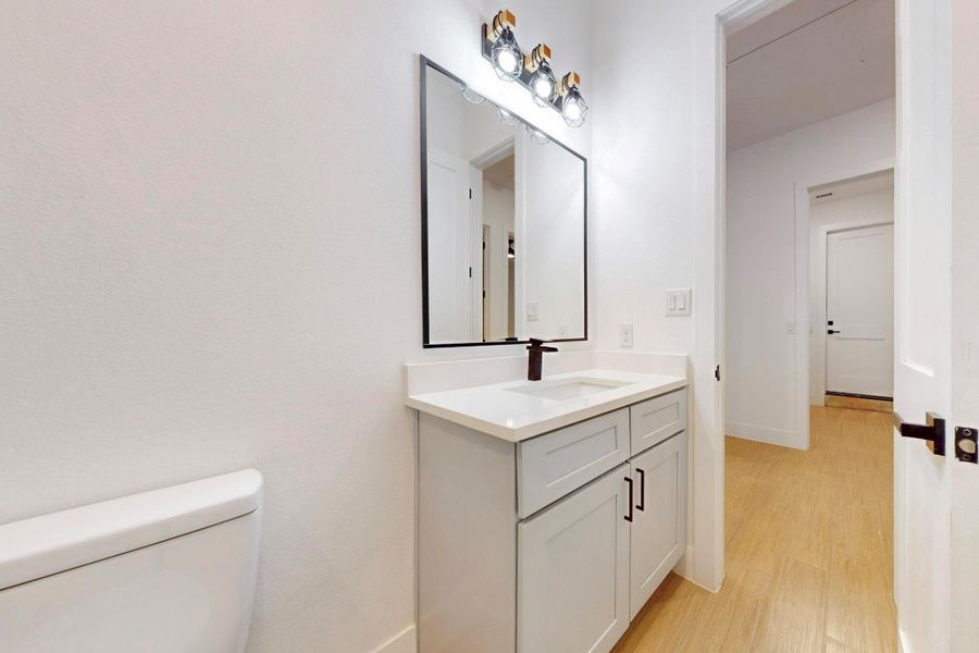 Half bathroom featuring vanity and light wood finished floors