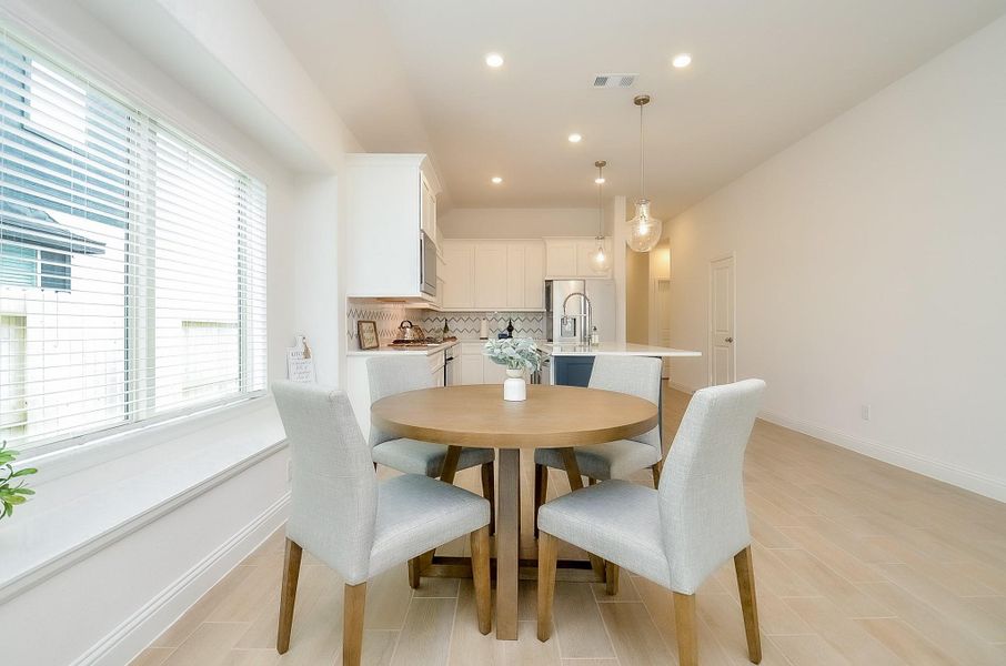 Bright and airy kitchen-dining area with modern white cabinetry.
