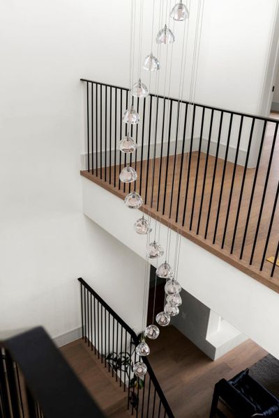 Staircase with wood finished floors and a high ceiling