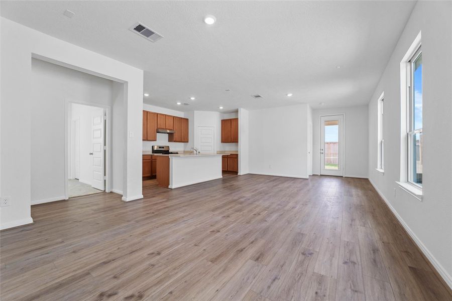 Bring family and friends together in this beautiful Great Room! It features high ceilings, recessed lighting, custom paint, stunning vinyl plank flooring, and large windows that fill the space with natural light all day long.