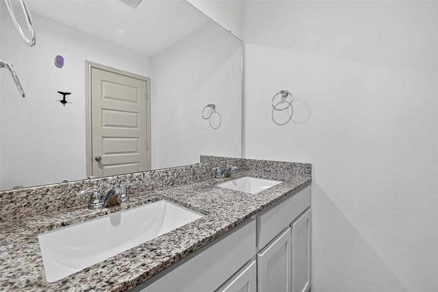 The secondary bathroom on the second floor also features double sinks for convenience.