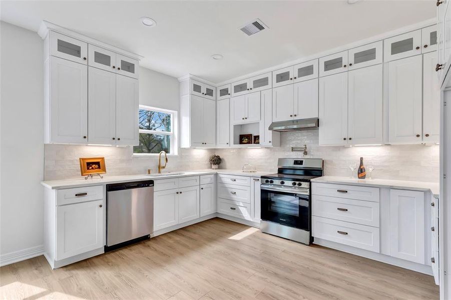 Expansive kitchen featuring a pot filler and elegant floor-to-ceiling custom cabinetry.