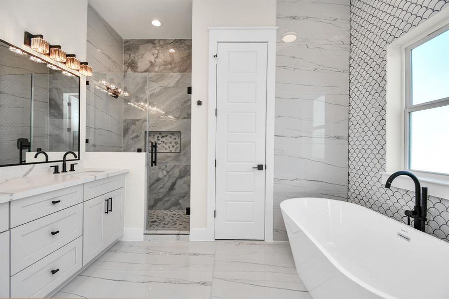 Spa-like bathroom featuring dual vanities, a soaking tub, and a walk-in shower.