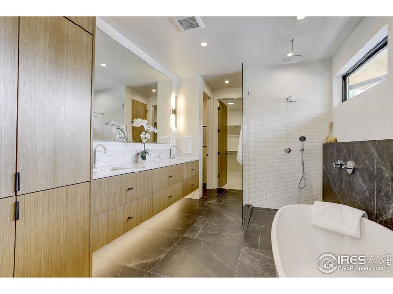 Master bath with heated tile floors, Porcelain slab shower and free standing soaking tub