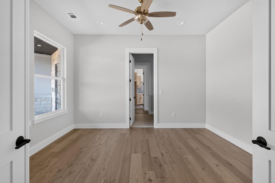 Gleaming hardwood floors and a tall window bring warmth to this versatile secondary room.