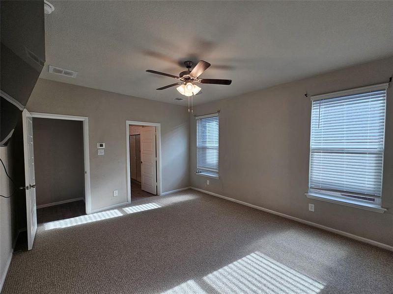 Primary bedroom featuring, moldings, carpet and a ceiling fan.