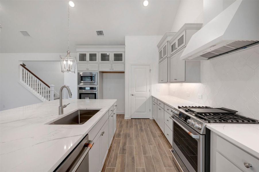 Stylish kitchen with stacked cabinets and quartz counters