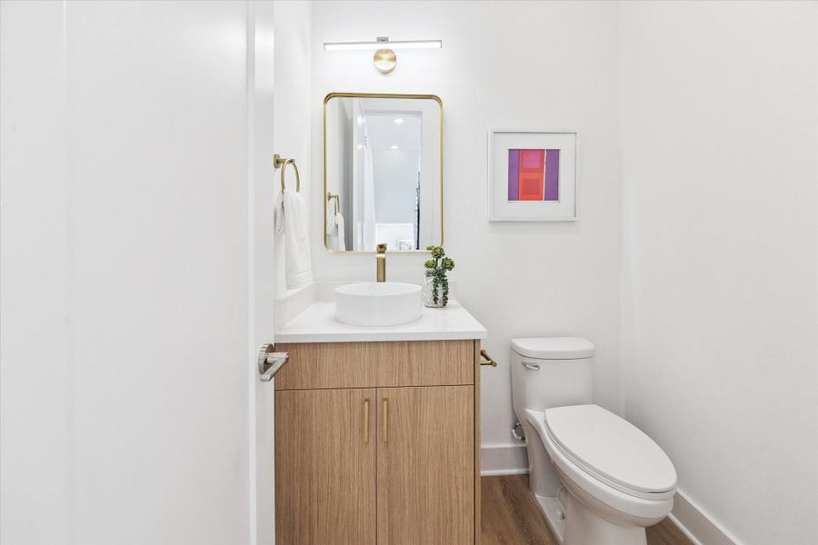 Conveniently tucked at the top of the stairs on the living level is a guest half bath, finished just as beautifully as the kitchen. Conveniently tucked at the top of the stairs on the living level is a guest half bath, finished just as beautifully as the kitchen.