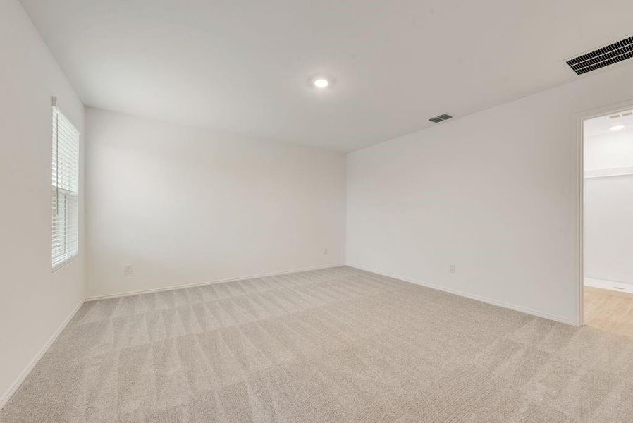 Spare room featuring light carpet, visible vents, and baseboards