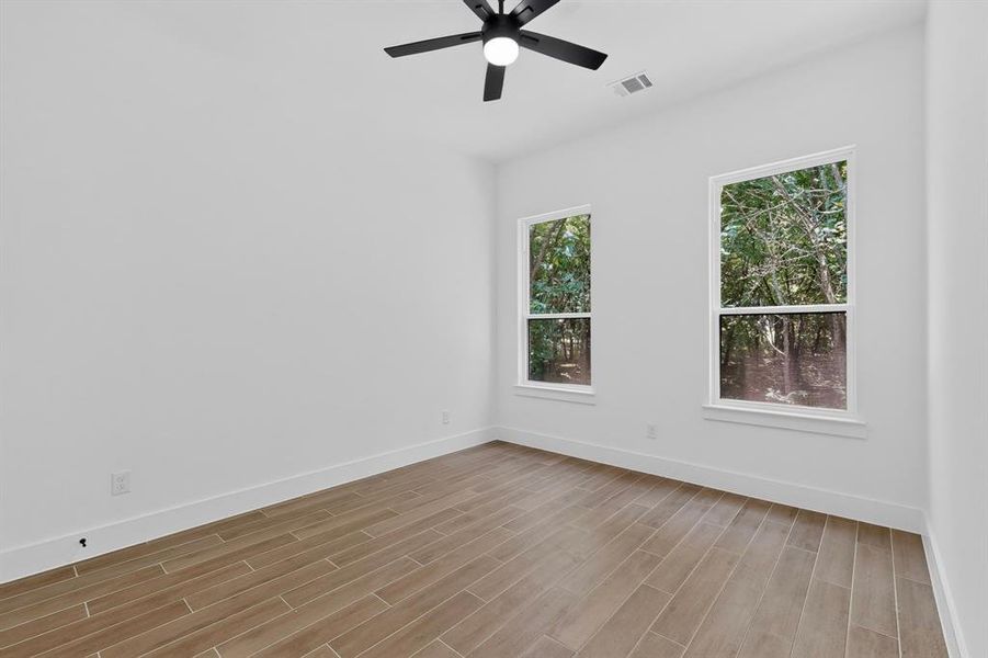 Bright room featuring wood-look tile flooring and two windows with white trim