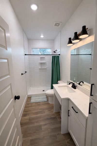 Bathroom with wood finish floors, vanity, a shower stall, and recessed lighting Bathroom with wood finish floors, vanity, a shower stall, and recessed lighting