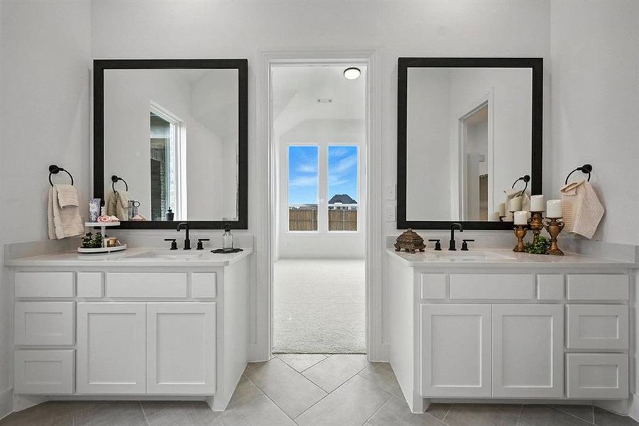 Bathroom with two vanities and light tile patterned floors