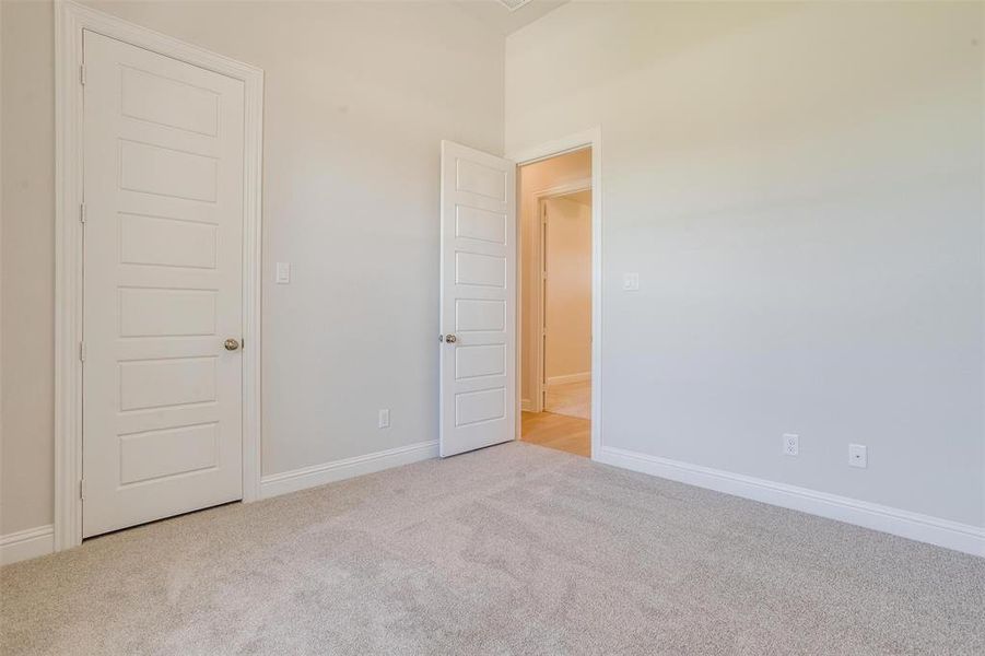 Spare room featuring a towering ceiling and light carpet