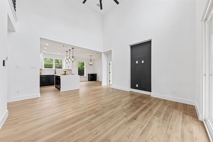 The property features vaulted ceilings, light wood-look flooring, and a modern kitchen with an island, dark cabinetry, and pendant lighting The property features vaulted ceilings, light wood-look flooring, and a modern kitchen with an island, dark cabinetry, and pendant lighting