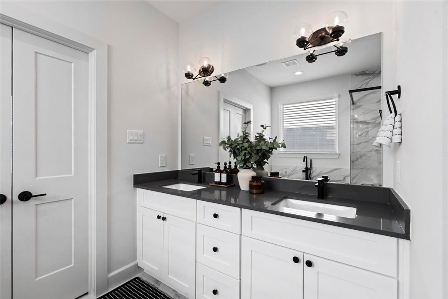 The double vanity offers separate space on each side, giving both people their own area to get ready without crowding. It’s a practical feature that keeps the bathroom organized and convenient.