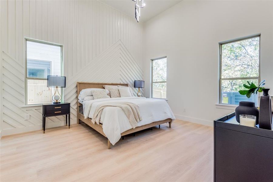 Bedroom with hardwood / wood-style flooring, high vaulted ceiling, and wood walls