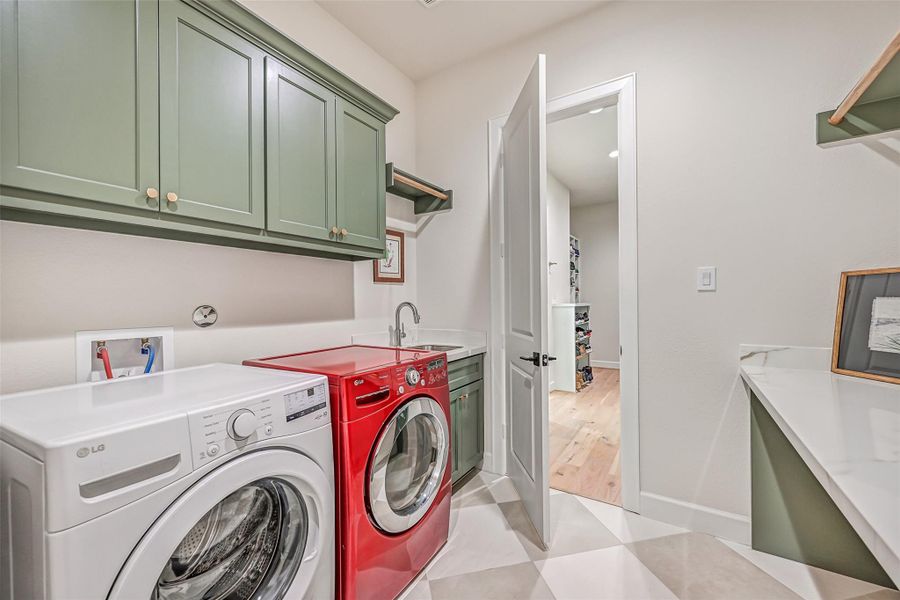 Thoughtfully positioned beside the primary suite, the utility room offers direct access from the primary closet along with a sink, custom cabinetry, hanging space and generous folding counters for an exceptionally functional layout.