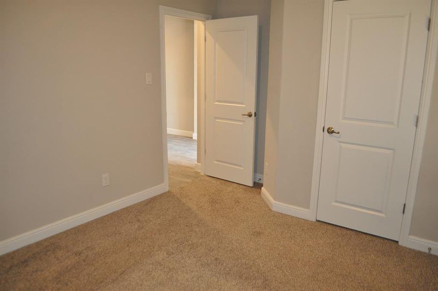 Unfurnished bedroom featuring light colored carpet