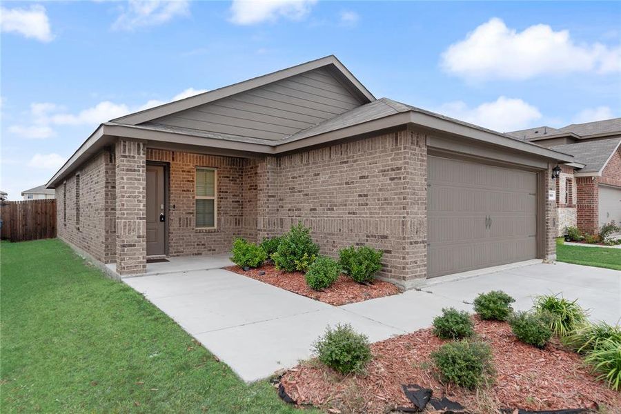 View of front of house featuring brick siding, a garage, and driveway