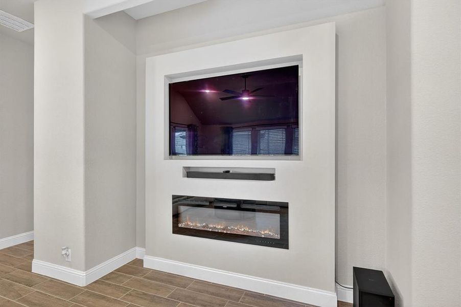 Built-in media wall featuring an electric fireplace, recessed television space, and integrated soundbar shelf Built-in media wall featuring an electric fireplace, recessed television space, and integrated soundbar shelf