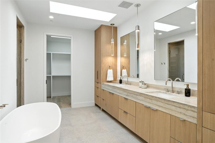 Bathroom with a skylight, double vanity, a freestanding bath, and recessed lighting Bathroom with a skylight, double vanity, a freestanding bath, and recessed lighting