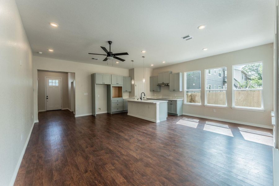 Open-concept living space featuring wood-finish flooring, recessed lighting, and a contemporary ceiling fan