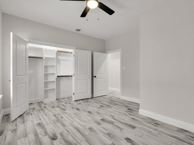 Unfurnished bedroom with ceiling fan, light wood-type flooring, and a closet