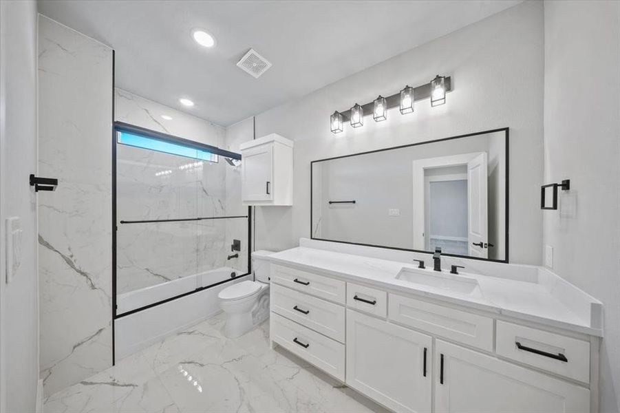 Full bathroom featuring bath / shower combo with glass door, vanity, and toilet