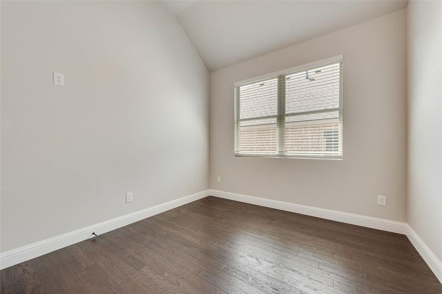 Spare room with lofted ceiling and dark wood-style floors Spare room with lofted ceiling and dark wood-style floors