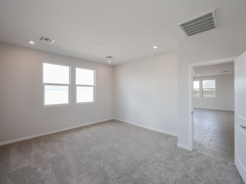 A room with a carpet and windows.