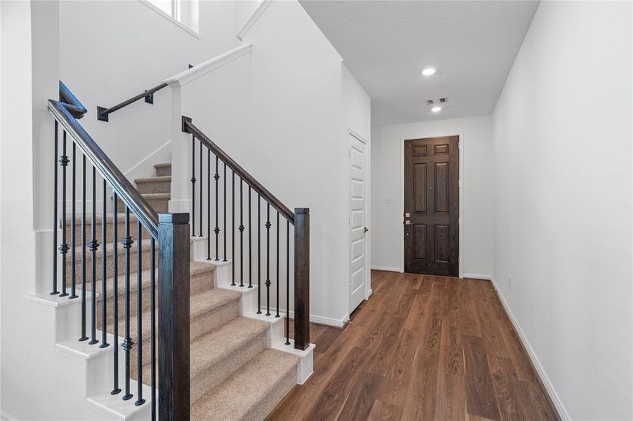 As you enter 571 Broken Boulder, you are welcomed with this beautiful grand staircase, custom paint, recessed lighting and gorgeous vinyl plank flooring!