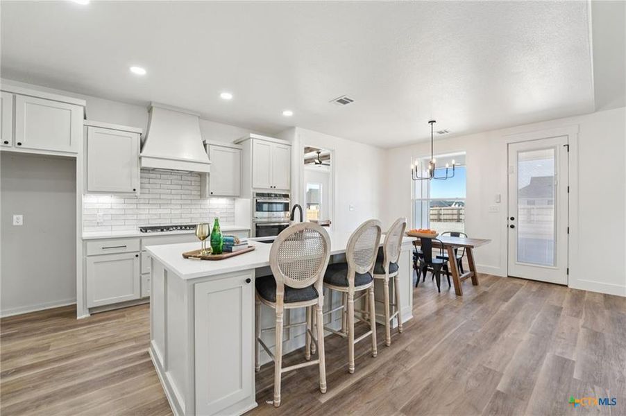 A pristine kitchen with an inviting island and elegant bar seating. A pristine kitchen with an inviting island and elegant bar seating.