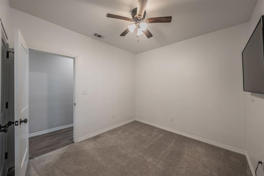 Carpeted spare room with baseboards and a ceiling fan Carpeted spare room with baseboards and a ceiling fan